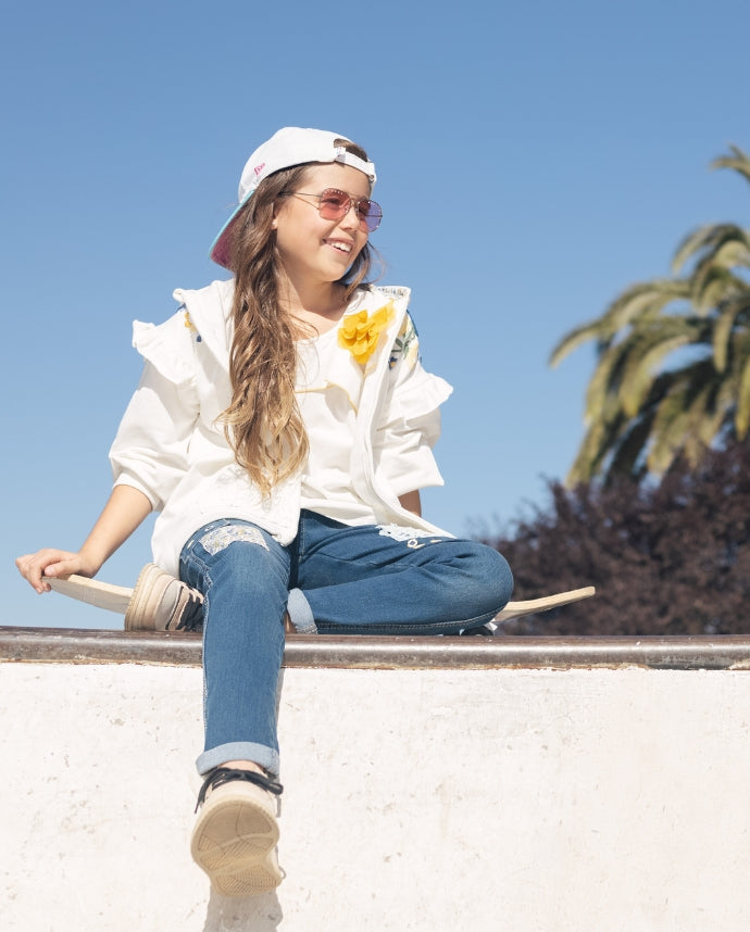 Girl model showcasing Limonada's stylish side, posing confidently with a skateboard.